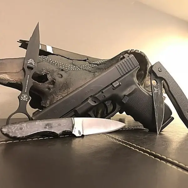 EDC flat-lay: Glock 21, spare mag, tactical flashlight, folding knife on canvas