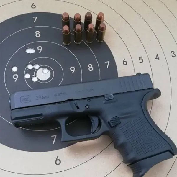 EDC flat-lay: Glock 29, spare 10-round mag, tactical flashlight and field knife