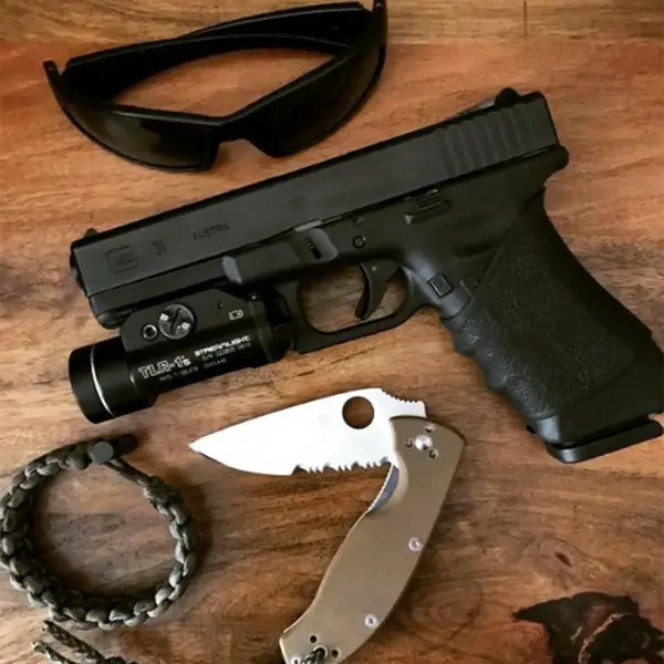 EDC flat-lay: Glock 31 with weapon light, spare magazine and folding knife