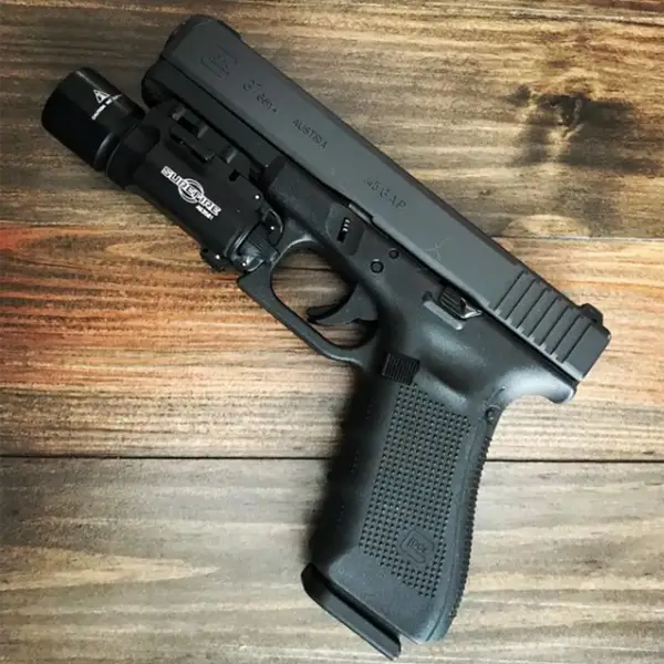 Field shot: Glock 37 with SureFire light and 10-round magazine on rough wood